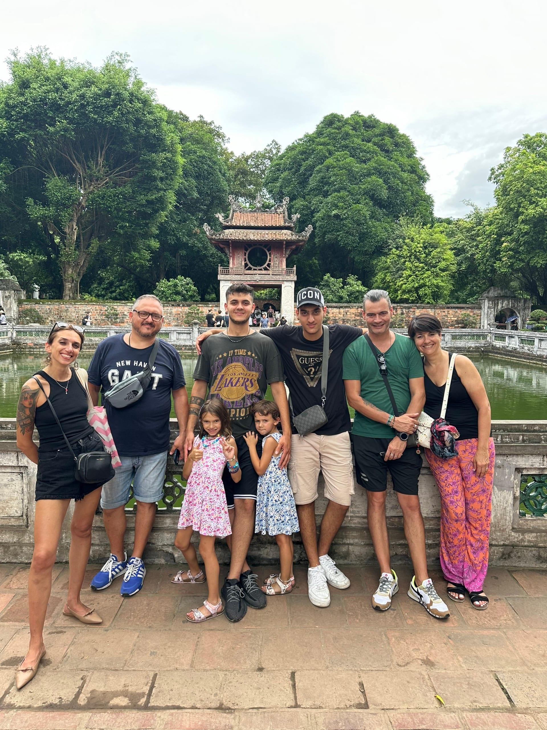 Una famiglia in piedi, tutti insieme, davanti al portale di un tempio