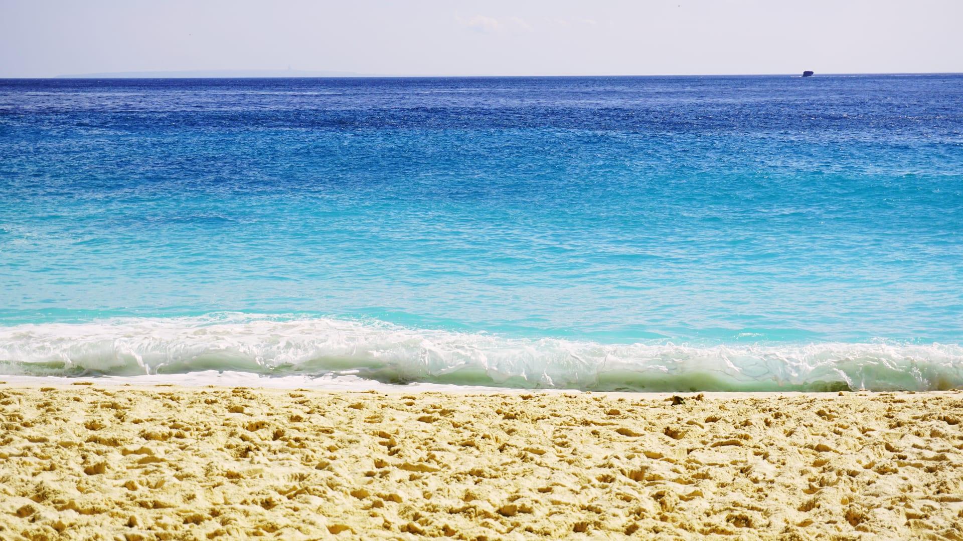 Il mare turchese che si infrange su una spiaggia di sabbia dorata