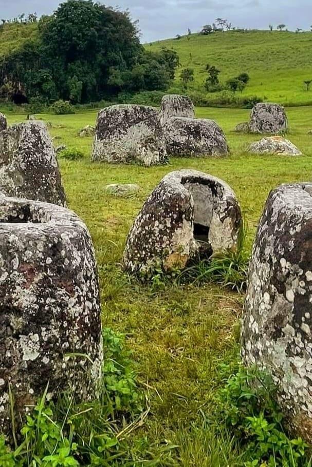 Grandi giare di pietra antiche adagiate in un prato verde