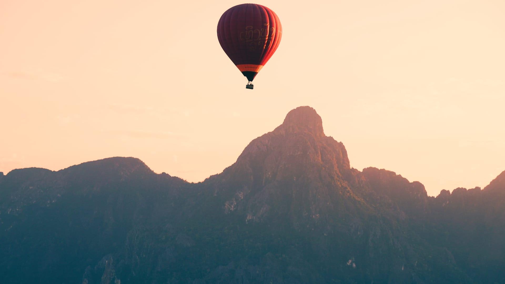 Una mongolfiera che fluttua sopra picchi calcarei all’alba