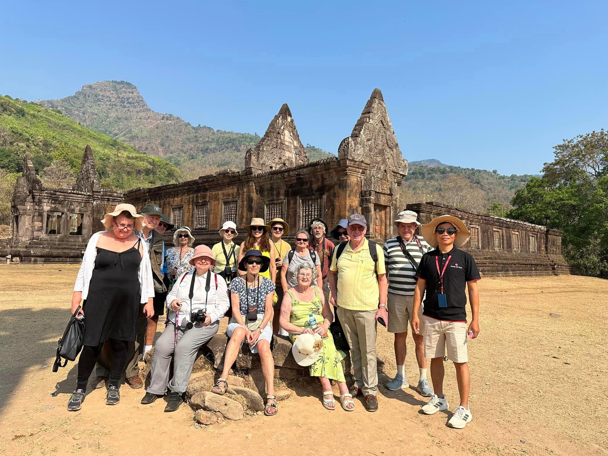 Un gruppo di viaggiatori riuniti davanti a un antico tempio di pietra