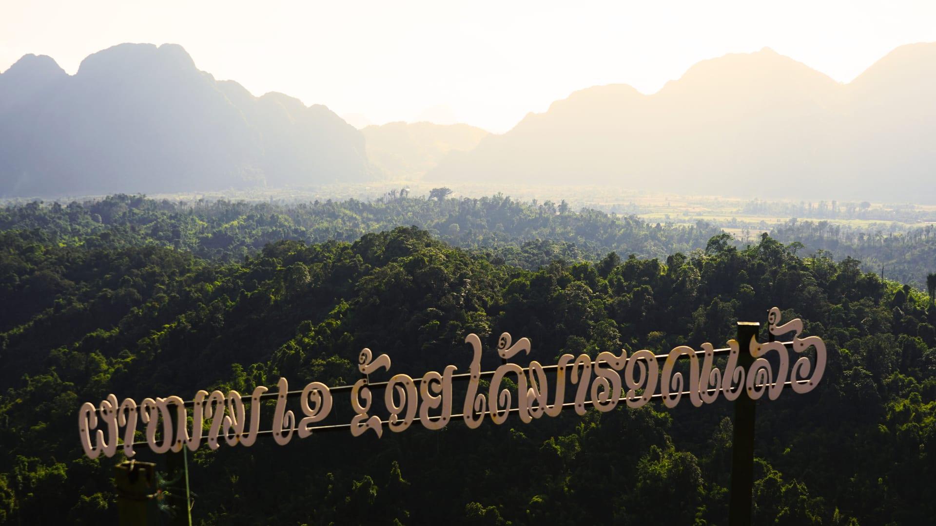 Forested limestone hills above a valley in morning haze