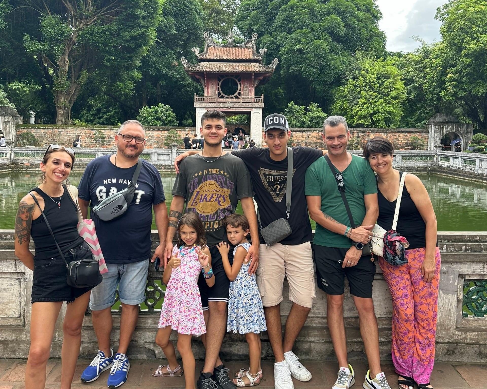 Famiglia di viaggiatori davanti a un tempio di Hanoi