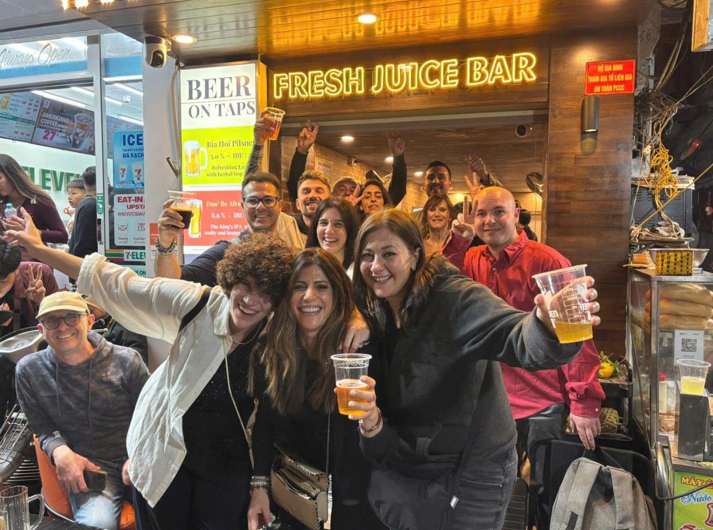 Gruppo con i bicchieri di birra in un locale della città vecchia di Hanoi
