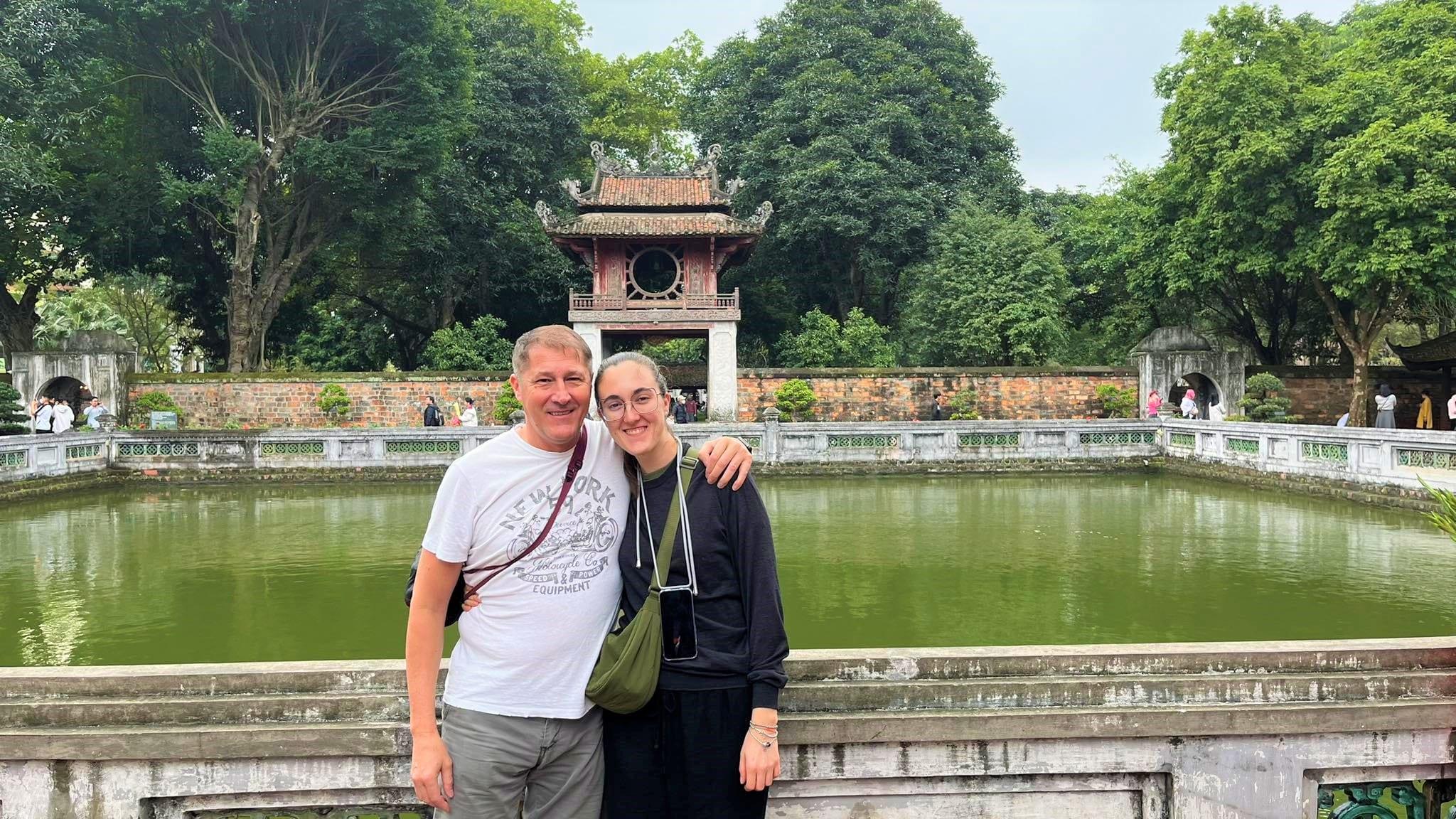 Una coppia davanti al padiglione e al laghetto del Tempio della Letteratura, ad Hanoi