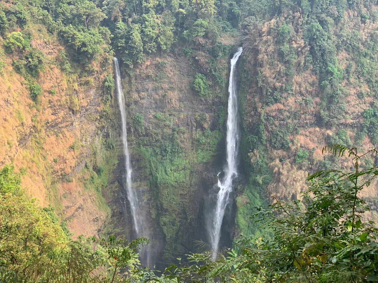 Due alte cascate che precipitano una accanto all’altra in una gola boscosa