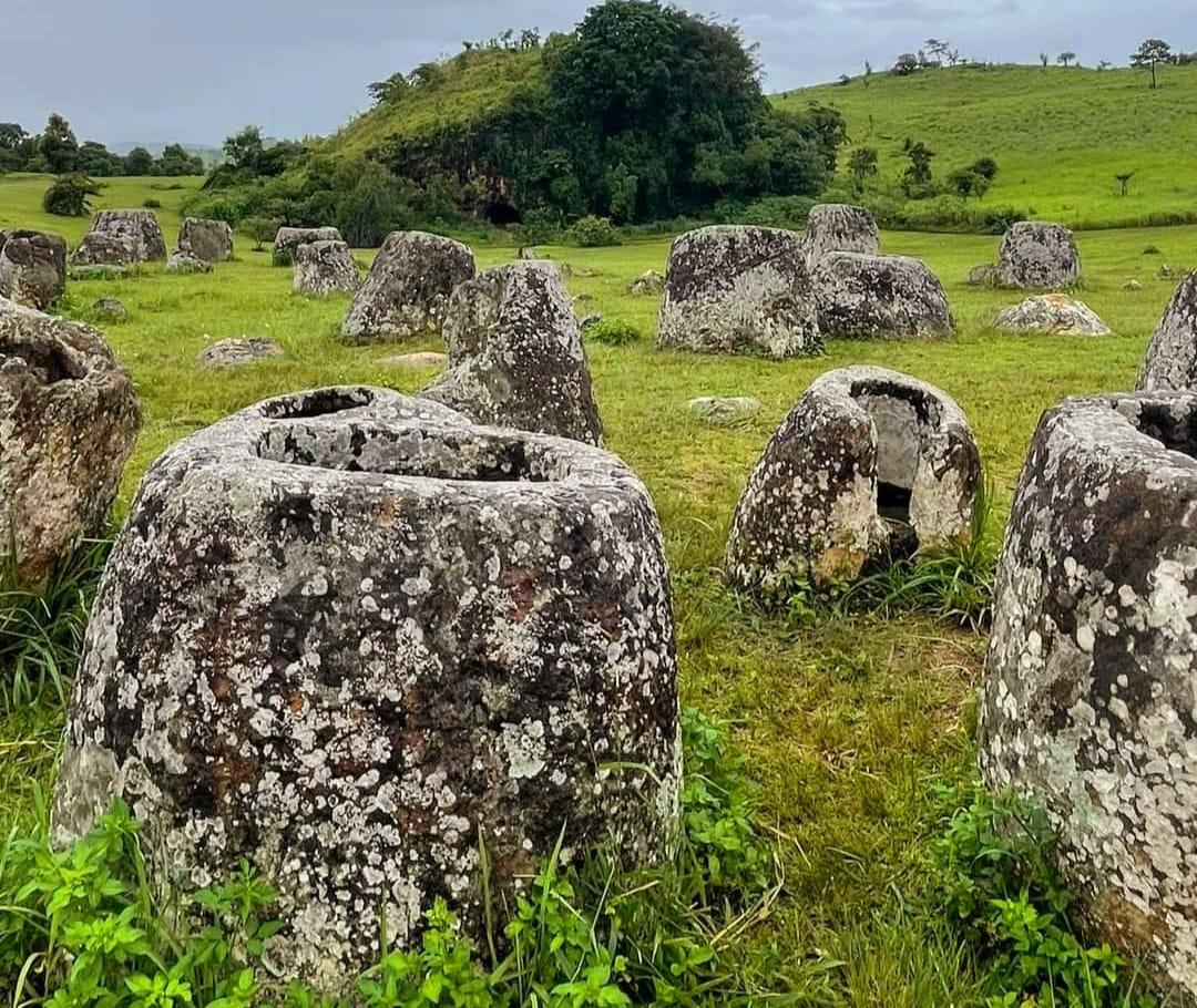 Un campo di antiche giare di pietra sotto un cielo azzurro